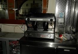 A stainless steel coffee machine badly fire damaged.