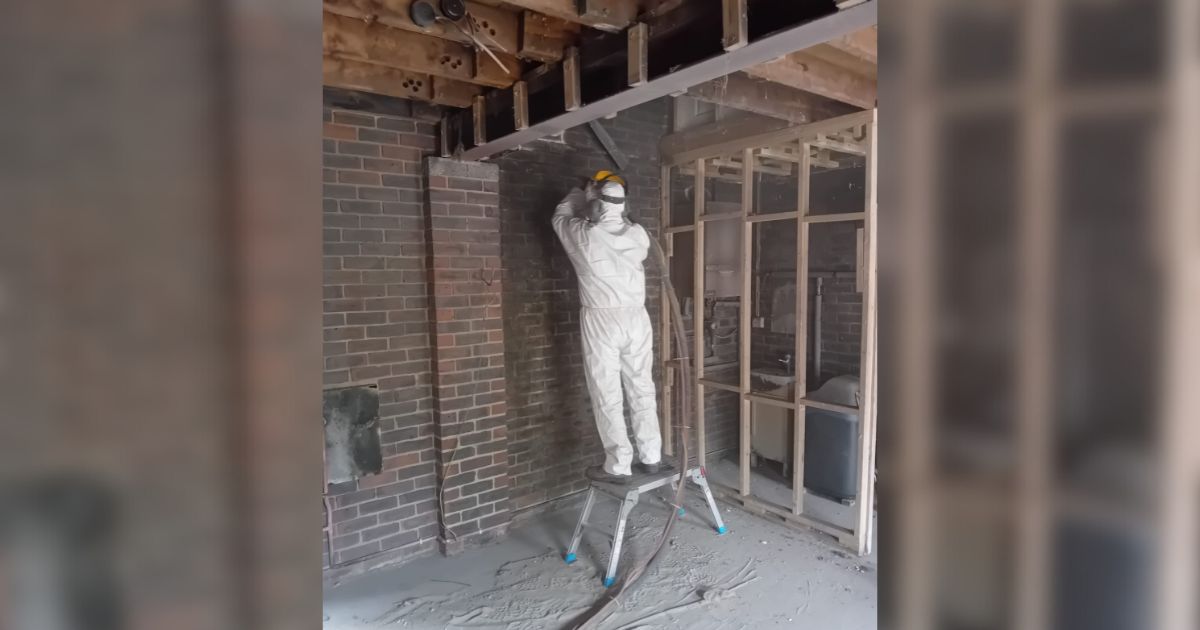 A Vinci technician wearing PPE clothing helping to clean and remediate a fire damaged property.